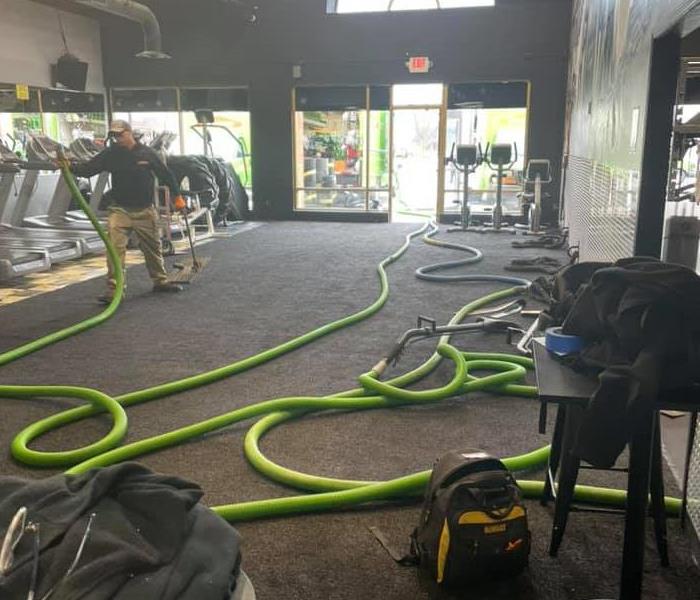 The image shows SERVPRO equipment being used to dry out a local gym.